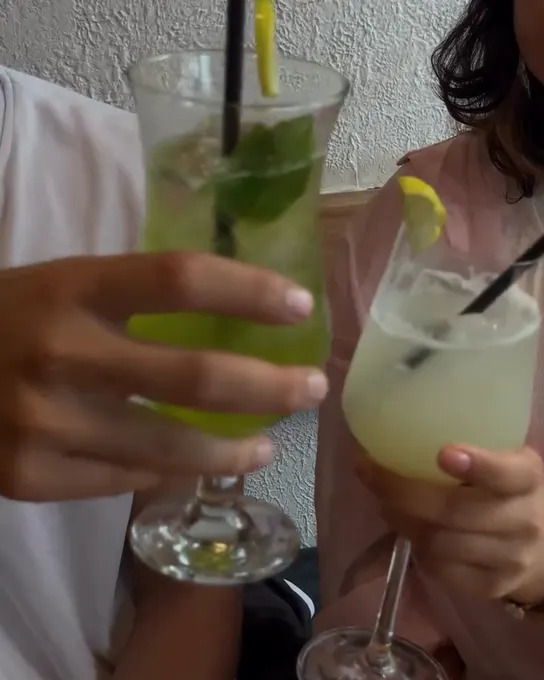 Two mint mojitos raised for a toast